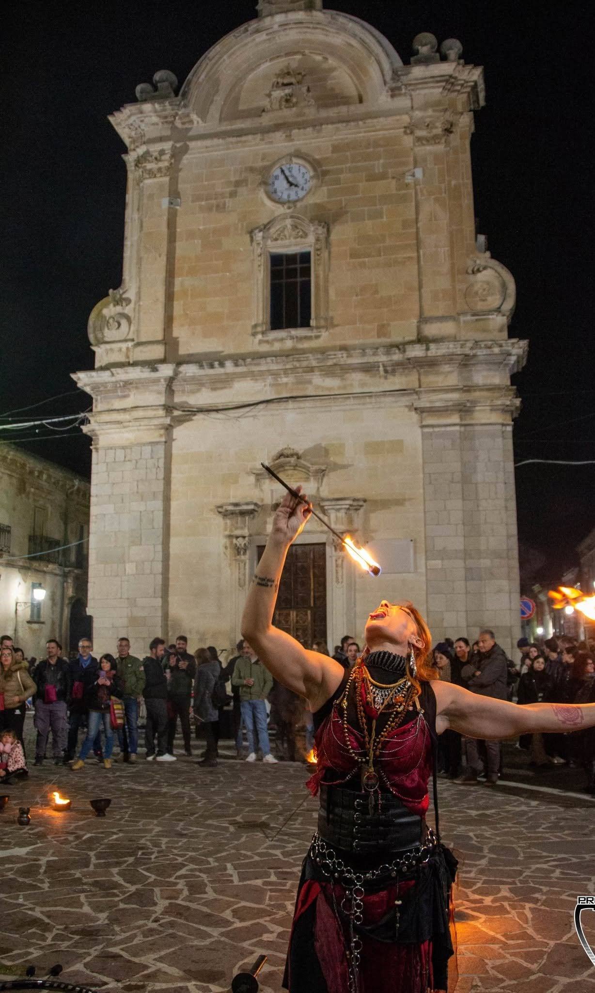 Artista con le torce davanti alla chiesa illuminata, vista verticale